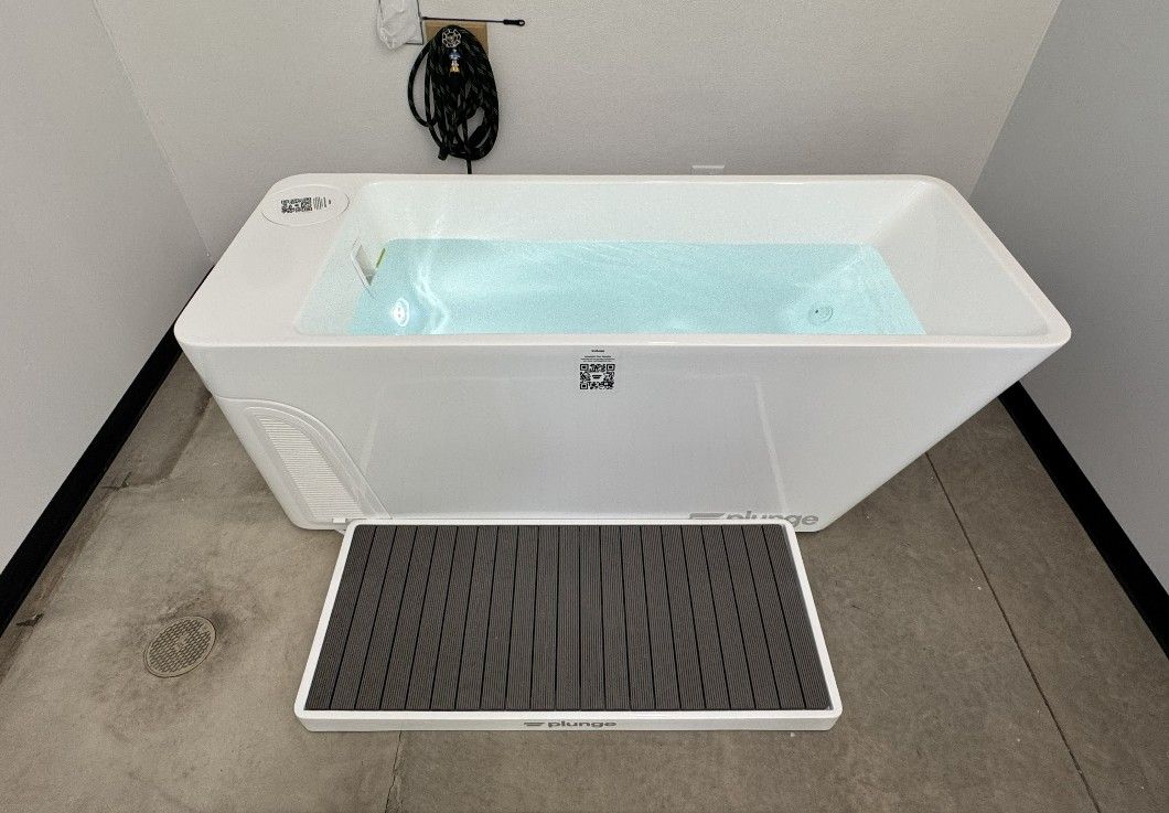 White cold plunge tub filled with chilled water