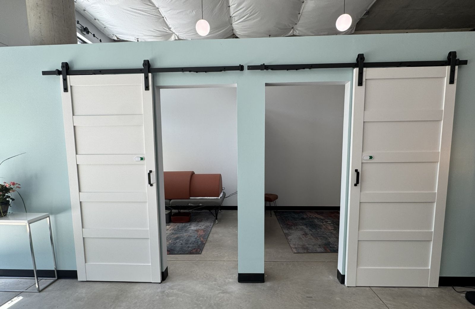 Sliding barn doors opening to the private sauna and cold plunge rooms of the Contrast Suite