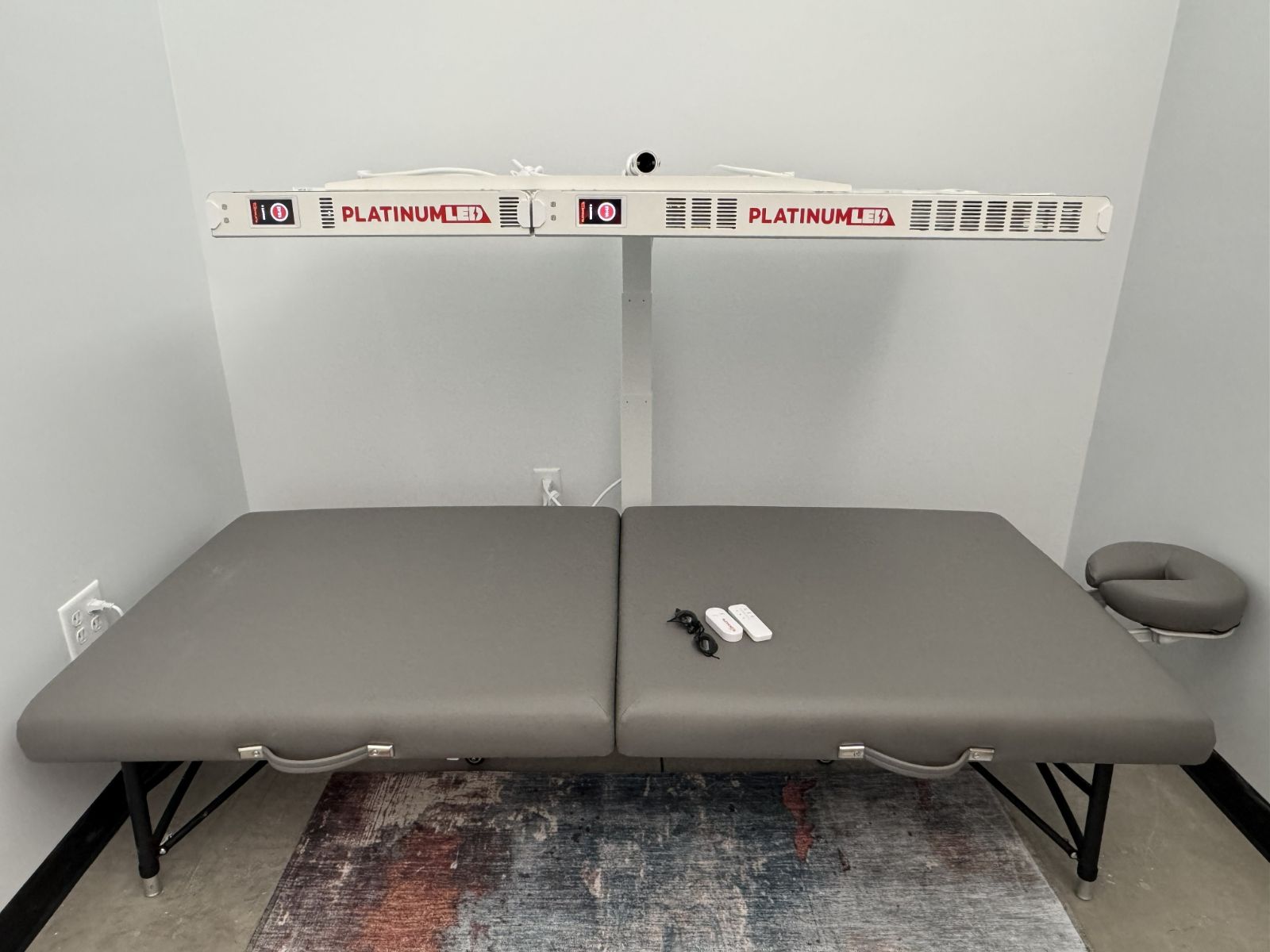 Red light therapy room with PlatinumLED BIOMAX panels above a massage table at Amplify Wellness in Eugene